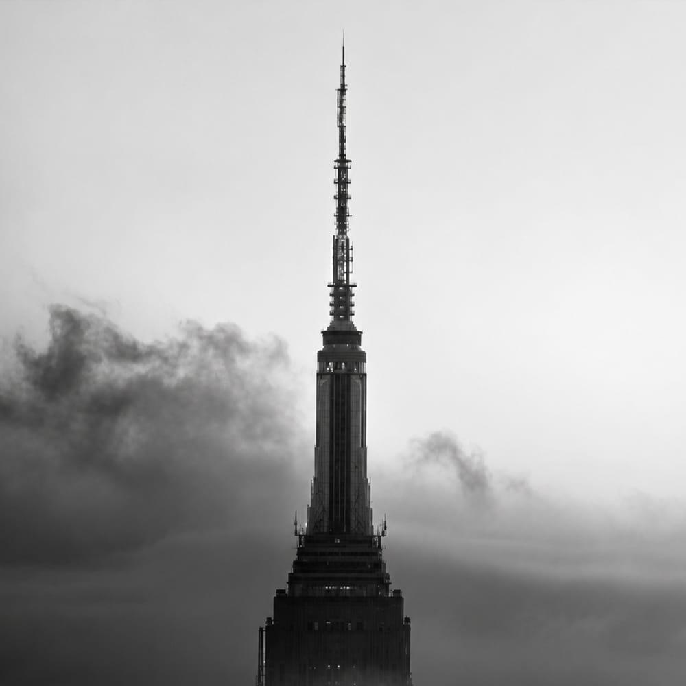 Tall tower emerging from fog black and white minimalist architecture photography