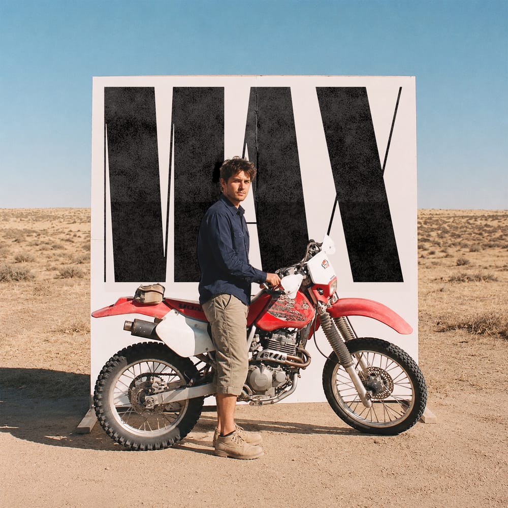 Person standing beside motorbike in desert landscape editorial photography