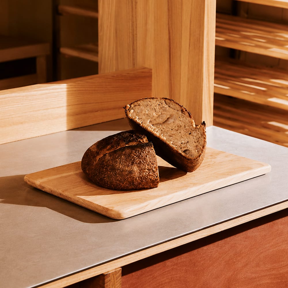 Sliced sourdough bread on wooden cutting board minimal food photography