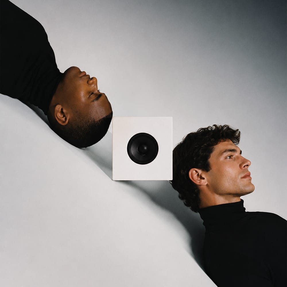 Dark editorial portrait of two men in high contrast black and white photography