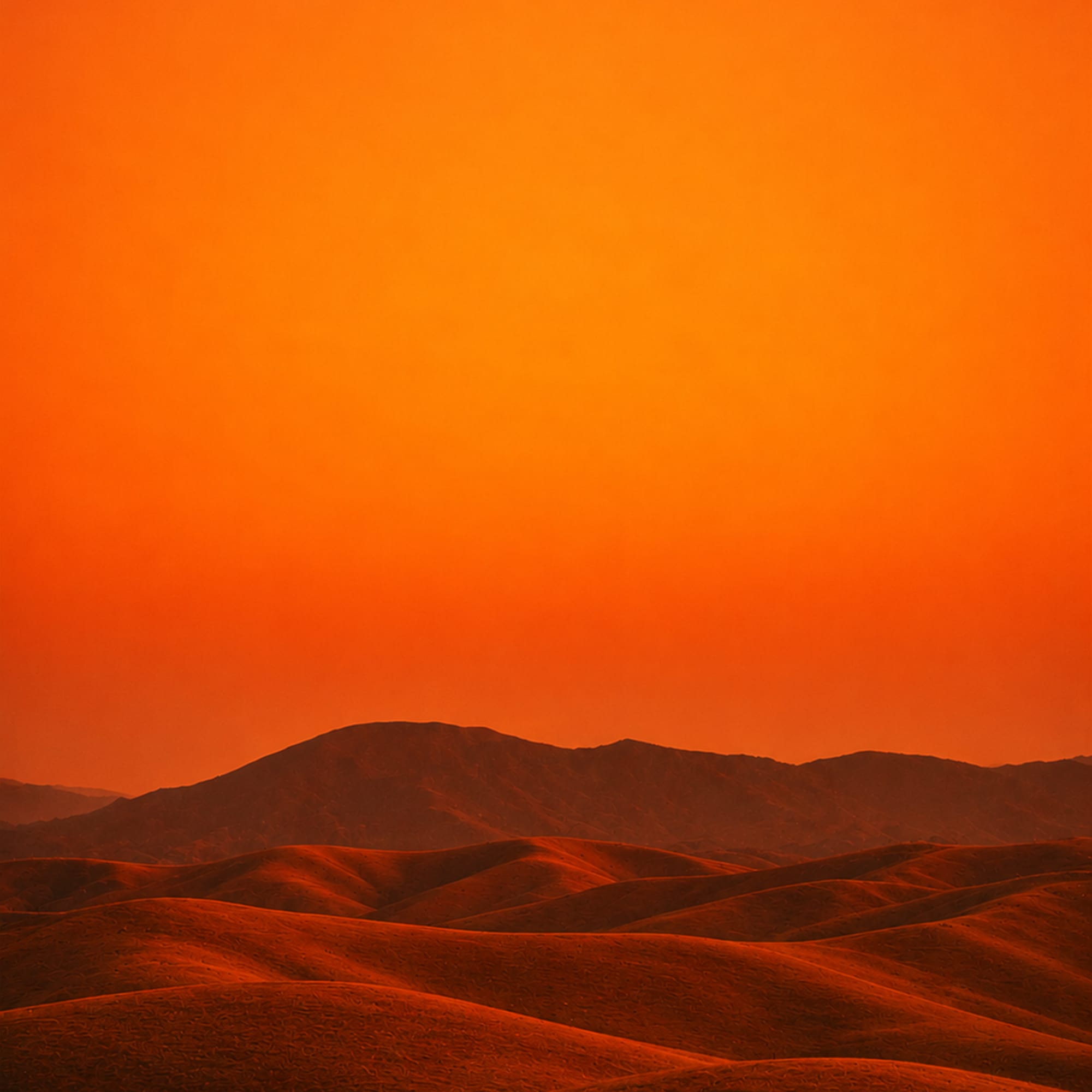 Desert sand dunes at golden hour with deep orange gradient sky